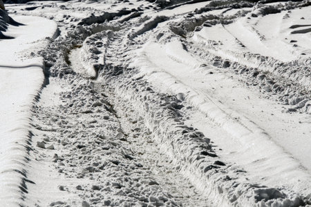 Traces of car tires on the white snow, close-upの写真素材