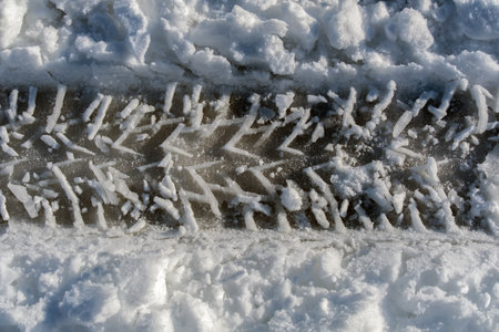 traces of car tires on the snow, closeup of photoの写真素材