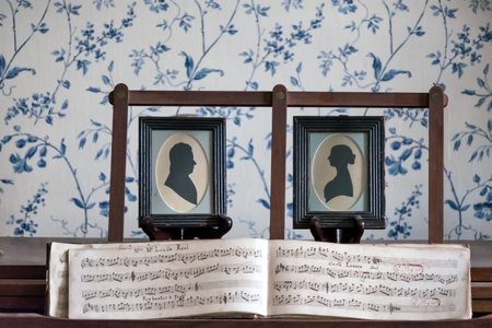 Two vintage photo frames on a wooden table in a church with an old book.の写真素材