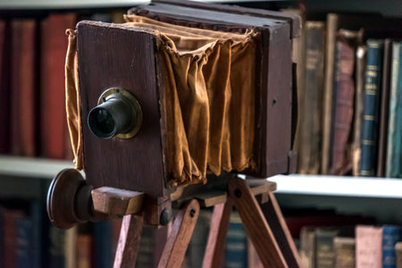 Antique wooden camera on the background of old books in the library