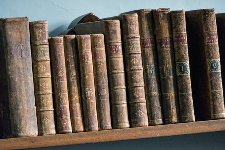 Pile of old books in a bookcase, closeup of photo