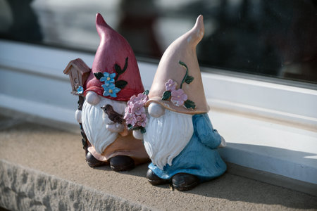 Sculpture of two gnomes on the windowsill.の写真素材