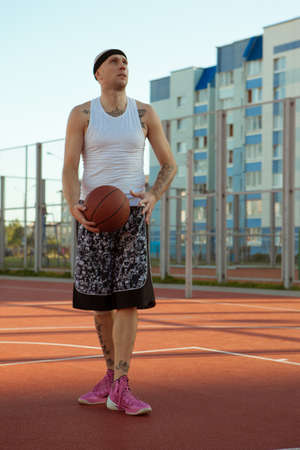 Guy in sports uniform stands with the ball in his hands.の写真素材