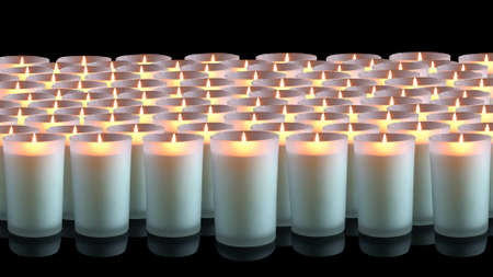 Many white candles on a black backgroundの写真素材