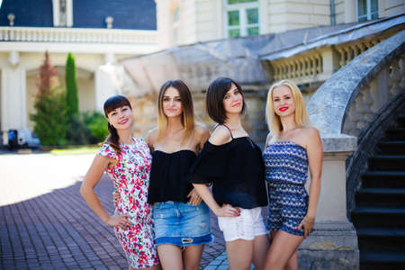four beautiful girls posing in front of in the city.のeditorial素材