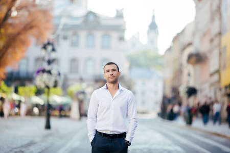 young man in shirt and glasses standing on city streetの写真素材