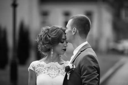 Elegant bride and groom posing together outdoors on a wedding dayの写真素材
