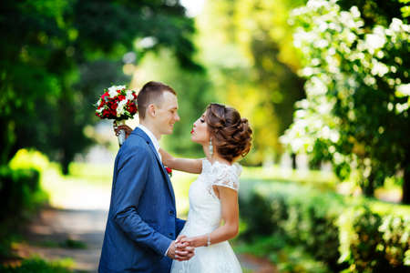 Wedding couple, happy newlyweds and husband hugging in green park.の写真素材