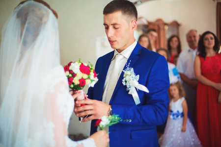 girl in a white dress at home. Bride with makeup. Wedding. Preparing the bride for the upcoming wedding.の写真素材