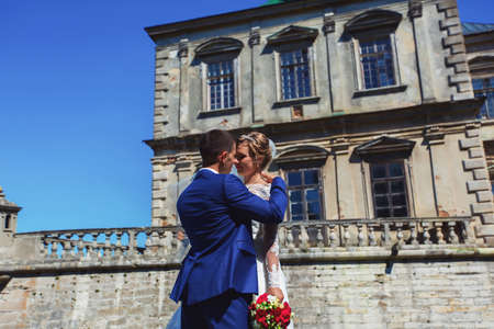 Romantic moment. Beautiful bride in a luxurious wedding dress and stylish bride in a tuxedoの写真素材