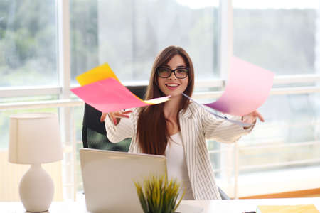 young girl businessman holding colored paper throwsの写真素材
