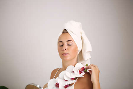 Young woman with beautiful face and fresh flowers. Skin care concept.の写真素材