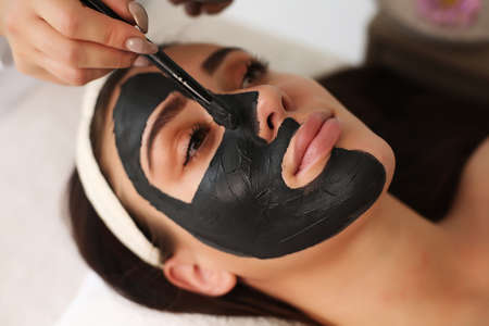 young beautiful woman with facial mask, spa treatmentの写真素材