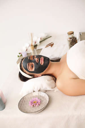 Spa concept. Young woman with nutrient facial mask in beauty salon, close upの写真素材