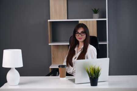 European brunette in a suit working at the table, solving casesの写真素材