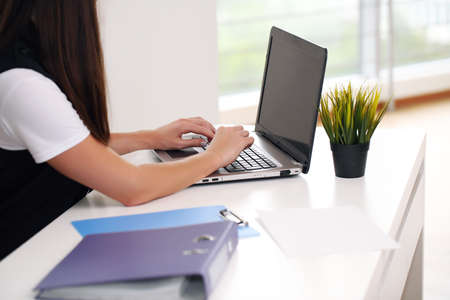 Young pretty business woman with notebook in the officeの写真素材