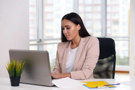 businessman in a pink jacket sitting at a laptop in the officeの写真素材