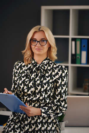 Business woman holding a writing tablet in the officeの写真素材