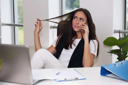 Attractive smiling young girl working on laptop computerの写真素材