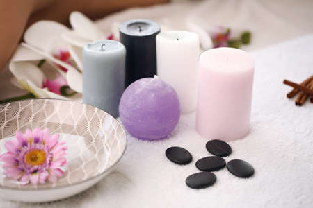 Basics for candles and spa on a towel in the bathroom, towel, sea stone, white orchids. Spa products set concept.の写真素材