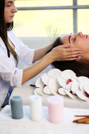 Beautiful young woman relaxing during traditional Thai massage at spa and wellness centerの写真素材