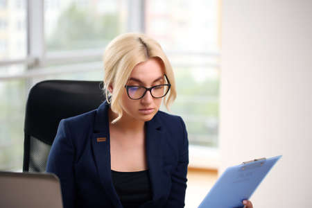 Work from home. Beautiful girl in a suit at the table,の写真素材