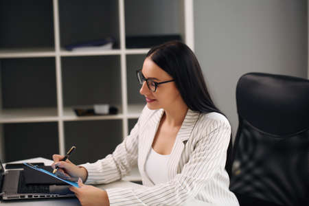 Focused woman working at her computer. Background for office startupの写真素材
