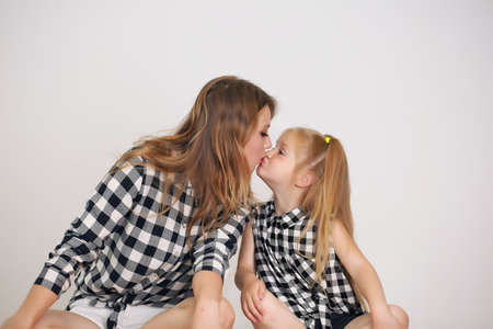 Happy loving family. Mother and her girl play, kiss and hug.の写真素材