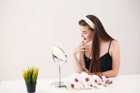 girl facial in front of a mirror, brunette has a hoopの写真素材