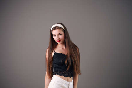 Sexy young girl with disheveled long brown hair wearing denim shorts with a high waistの写真素材