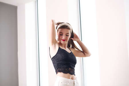 Sexy young girl with disheveled long brown hair wearing denim shorts with a high waistの写真素材