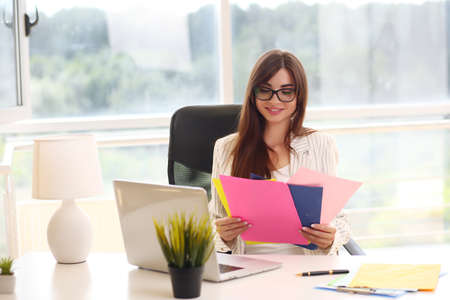 Adult young pretty business woman working in coworking. She is very busyの写真素材