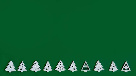 small figures of Christmas trees on a green background ,a Christmas concept with a place for textの写真素材