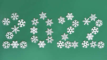 Christmas figures 2022 on a green background of figures of Christmas trees and snowflakes ,the concept of Christmas and new year with a place for textの写真素材