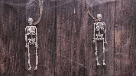 toy skeletons of a man on a rope on a wooden background , Halloween conceptの写真素材