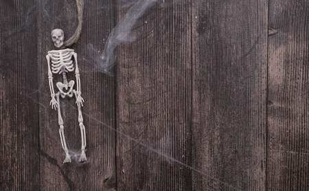 toy skeletons of a man on a rope on a wooden background , Halloween conceptの写真素材