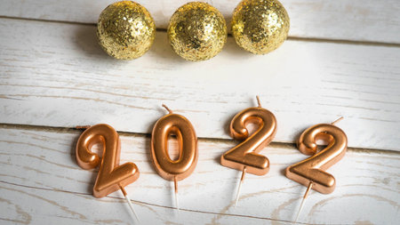 christmas figures 2022 on white wooden background with bokeh, christmas concept