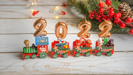 the figures of the new year 2022 on the Christmas locomotive of Santa Claus on a white wooden...