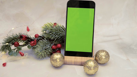 a phone with a green screen chromakey on a stand on a white wooden background with a credit card with New Years gifts, the concept of Christmas, gifts,black Friday and cyber Mondayの写真素材