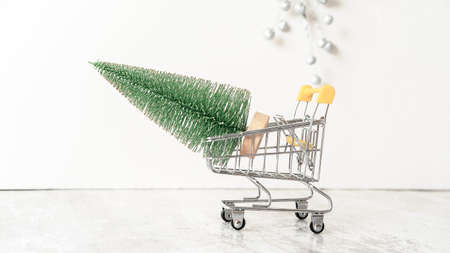 a small green Christmas tree figurine in a supermarket cartの写真素材
