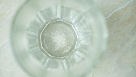scum at the bottom of a clear glass of water top viewの写真素材