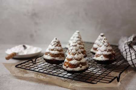 christmas cupcakes in the shape of Christmas trees in powdered sugar on a gray background , flat leiの写真素材