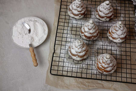 christmas cupcakes in the shape of Christmas trees in powdered sugar on a gray background , flat leiの写真素材
