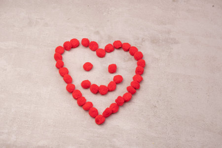 a heart made of fluffy balls on a red background .the concept of Valentines day and all loversの写真素材