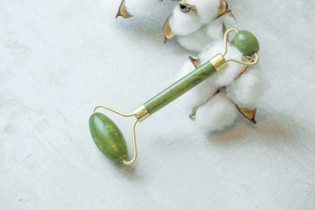 jade roller for facial massage gouache scraper brown bubble with serum , the concept of facial massage and home facial skin careの写真素材