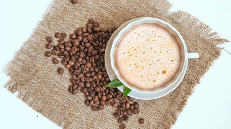 A cup of coffee and grains on a white background.