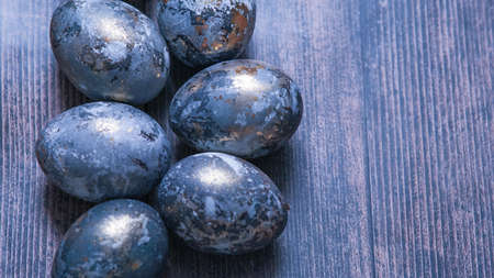 Easter card with a copy of the place for the text. Very Peri 2022 .Purple, blue eggs in a basket on a dark newspaper background. Natural dye karkade tea.の写真素材