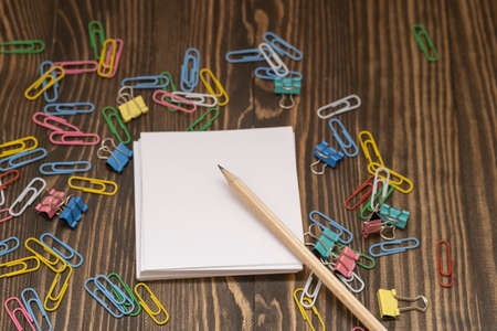 stationery colored paper clips around a mocap record sheet on a wooden background, the concept is coming to school soonの写真素材