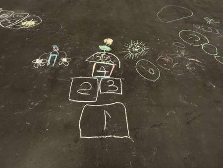 childrens chalk drawings on asphalt , classics , jumpers on asphaltの写真素材