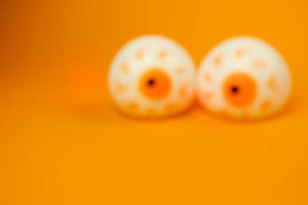 out of focus toy eyes on an orange background with a place for text, Halloween conceptの写真素材